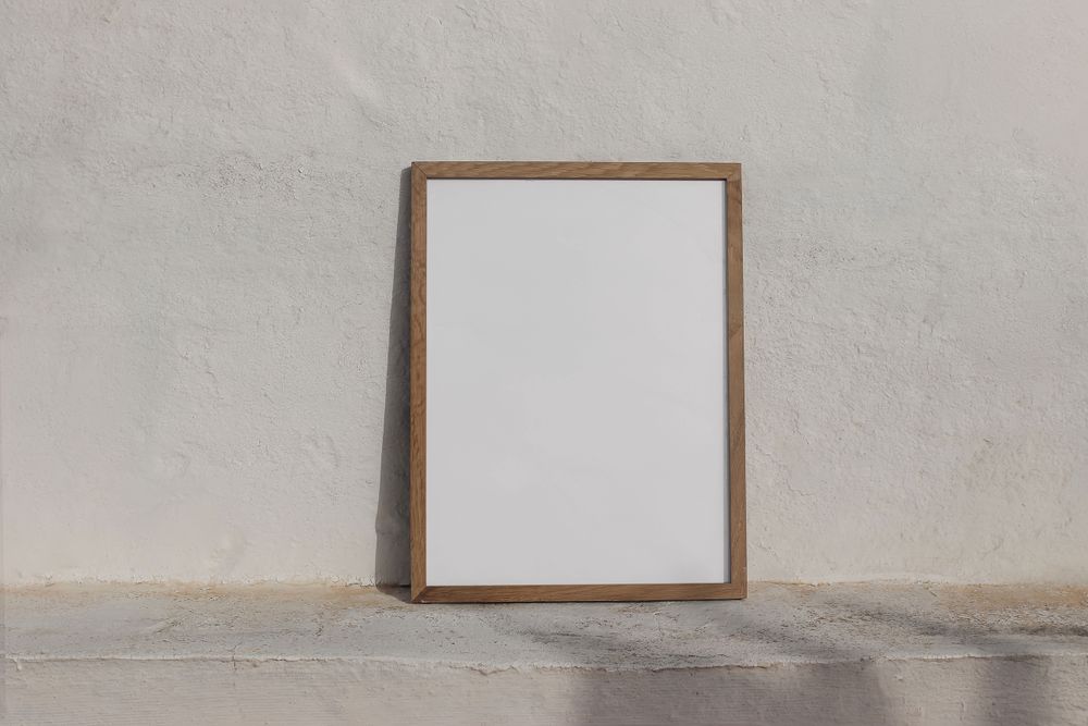 Minimal empty vertical wooden frame picture mockup against textured wall