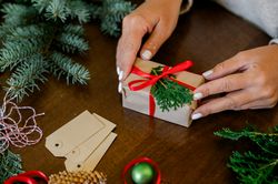 An unrecognizable woman holding Christmas gift in hand