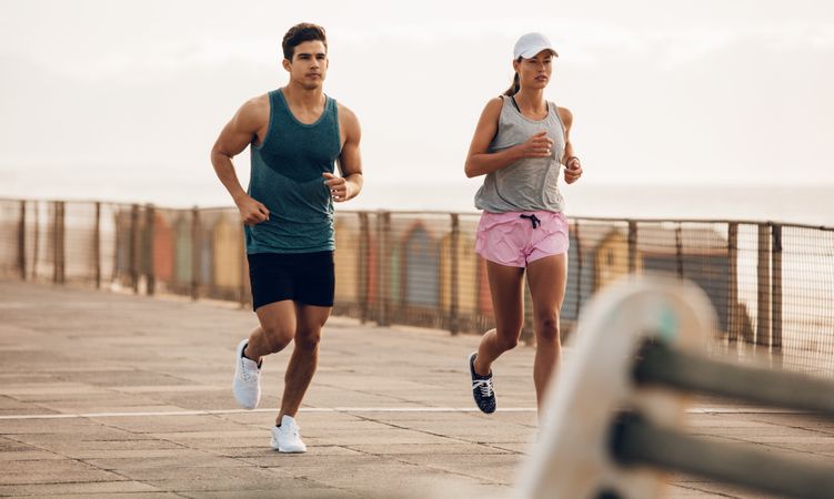 Fitness couple jogging on the sea side promenade