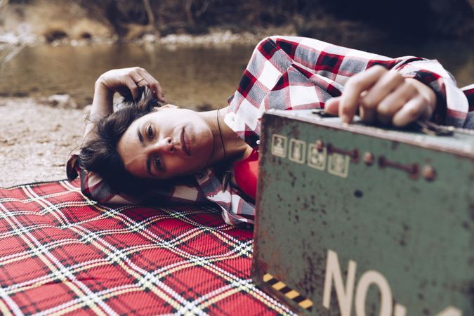 Cheerful woman with old case on picnic