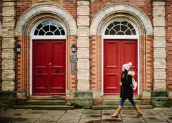 Woman passing red doors