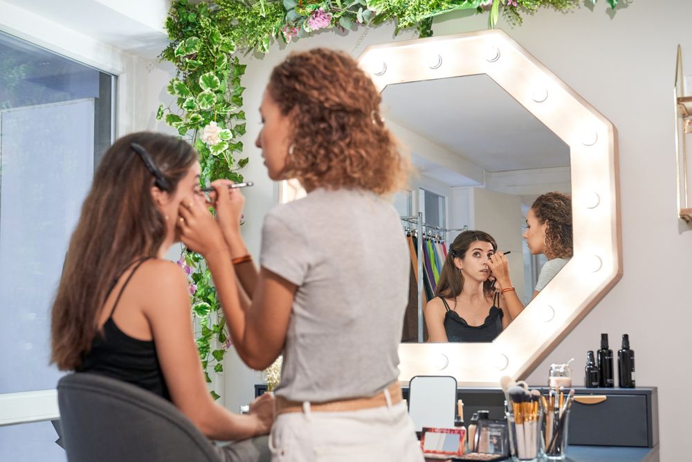 Woman applying makeup on model