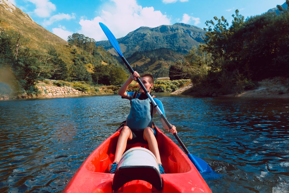 Young female kayaking on nature background
