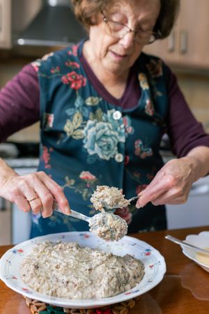 Patient woman coating croquettes dough with flour and egg