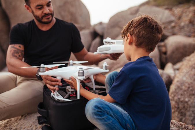 Young child helping his dad with a drone