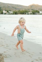 Little boy running on beach in sunny weather