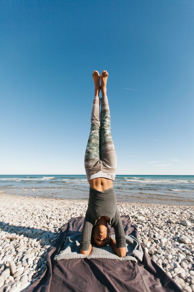 Sportive woman performing yoga posture in the beach