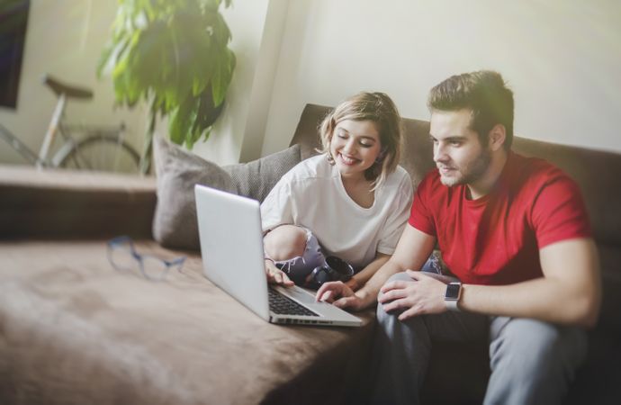 Couple browsing laptop on couch