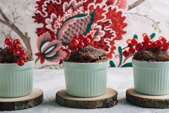 Three Chocolate cakes in the cup with currants and sugar glass.