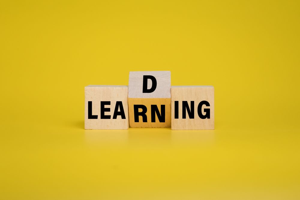 leading and learning words symbol on wooden blocks on yellow background