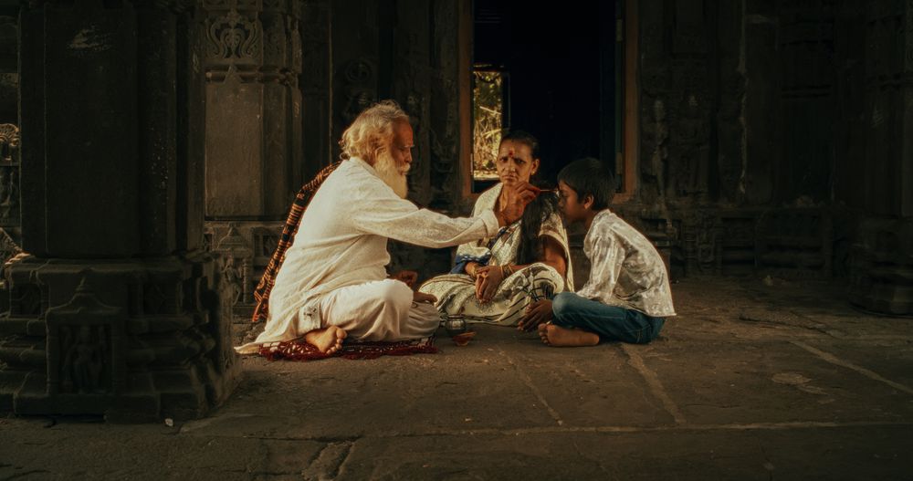 Authentic Footage of Hindu Priest Tying a Mauli Thread Around a Female Temple Follower's Wrist.