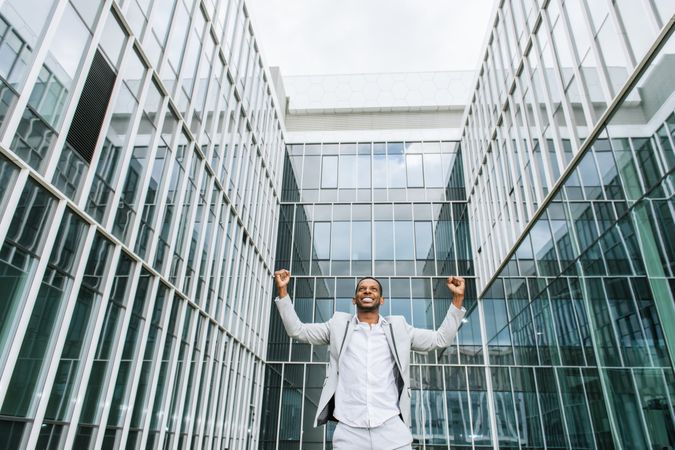 Enthusiastic Black man rejoicing raising hands up