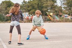 Teenagers playing basketball together in city
