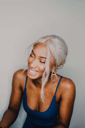 Charming Black woman in blue trendy dress laughing