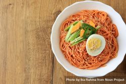 Top view Korean noodle dish plates with boiled egg and fresh vegetables 5o7Ey5