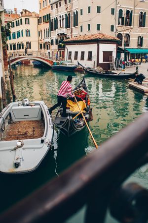Man in boat floating in canal between buildings