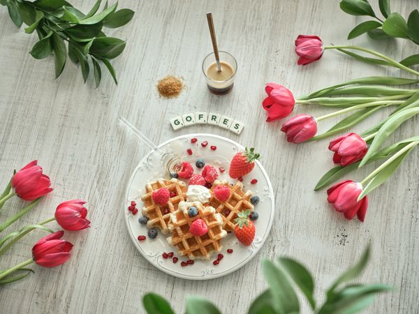 Dessert on plate near flowers and coffee with honey