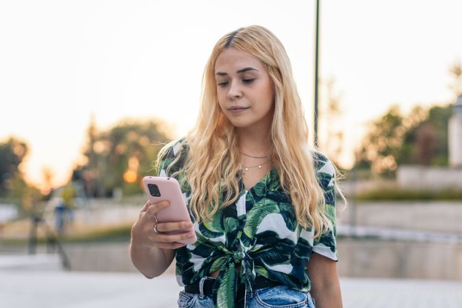 Blonde woman using mobile phone outdoors