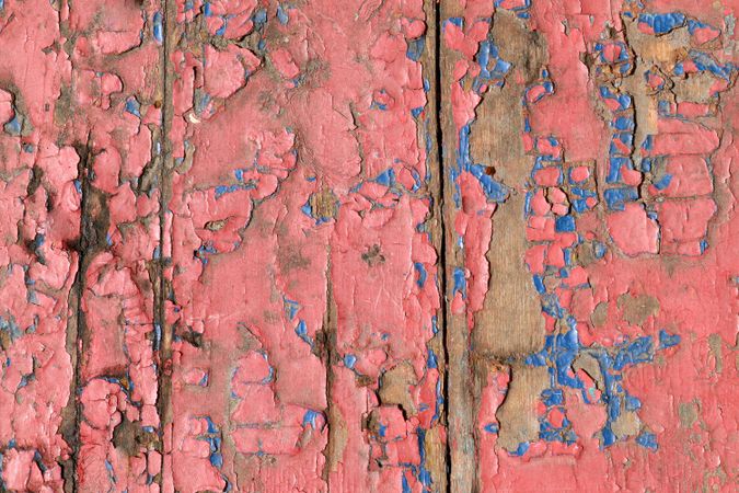 Cracked red paint on wooden background