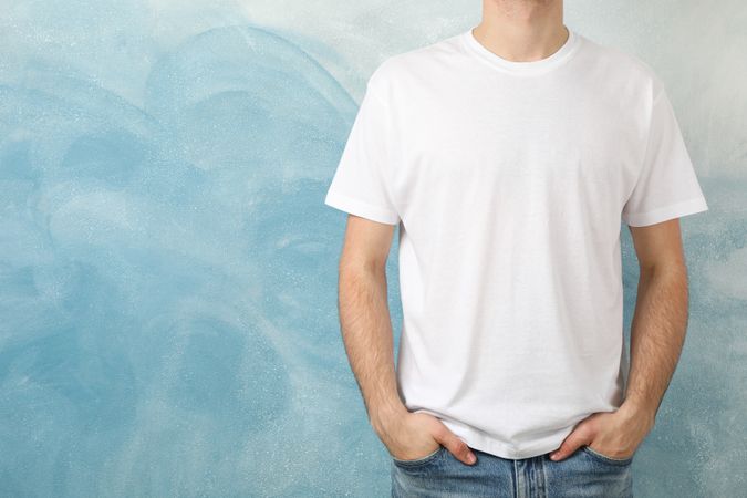 Men in blank t-shirt against blue background, space for text