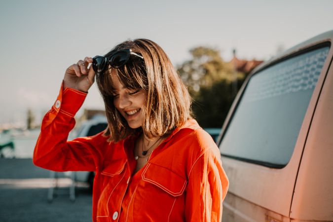 Woman in red jacket and sunglasses smiling