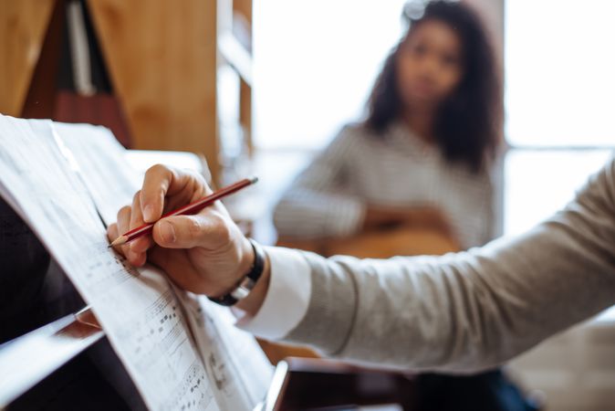 Man playing piano near woman playing guitar in studio