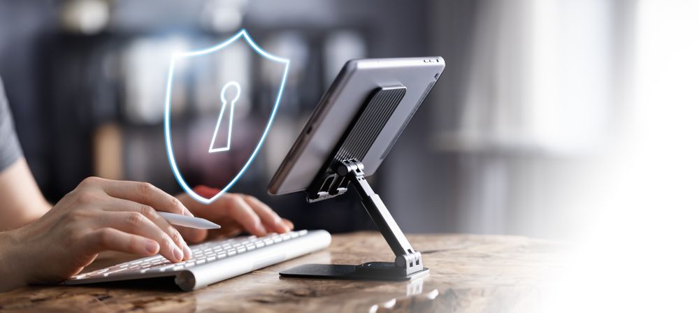 Man working on tablet with cybersecurity icon
