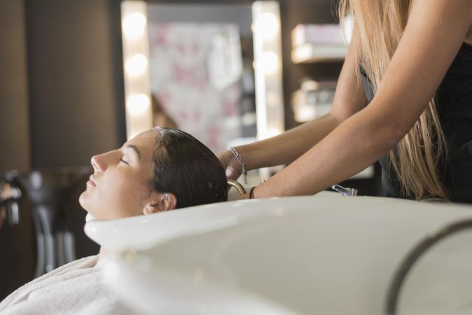 Calm female having her hair washed by stylist