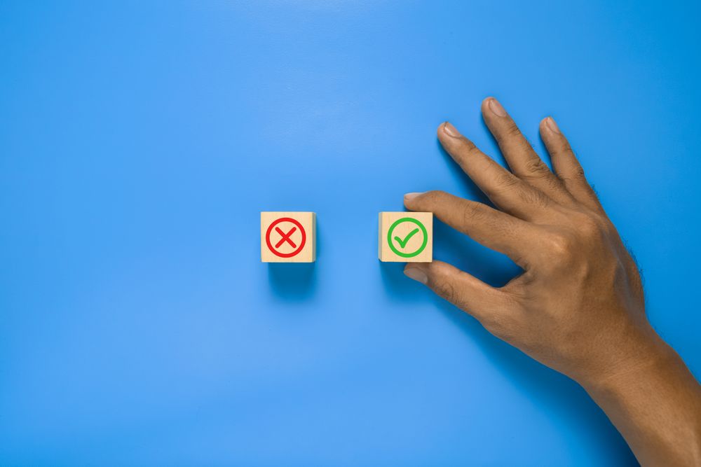 red and green cross and check sign symbol on wooden blocks