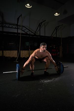 Strong concentrated man training with barbell