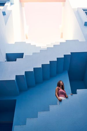Woman walking upstairs on modern blue building