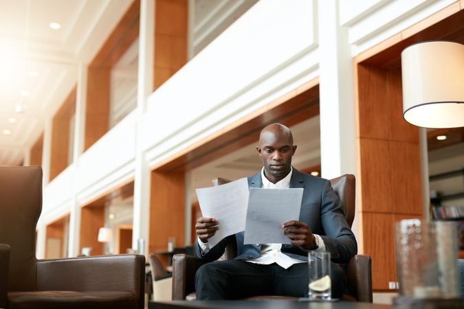 Portrait of busy businessman sitting at hotel lobby