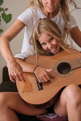 Blonde girl looking at camera while playing guitar