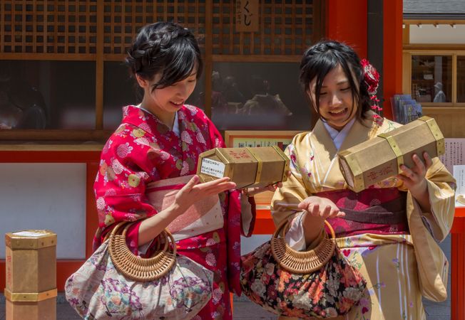 Japan - May, 10 2013: Smiling teenagers in kimonos examining boxes