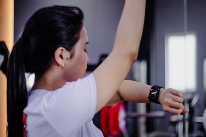 Focused woman monitors fitness progress with smart watch workout