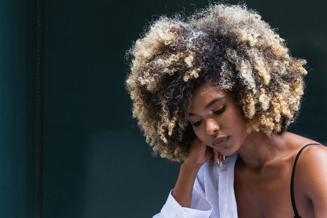 Pensive stylish Black woman standing near colorful door