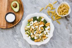 Bowl of cut chicken broccoli macaroni and cheese
