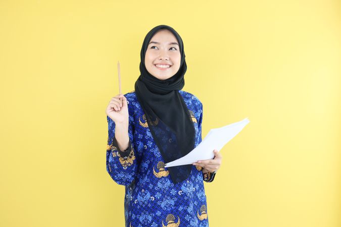 Female Wearing Korpti Batik Uniform Holding Pencil