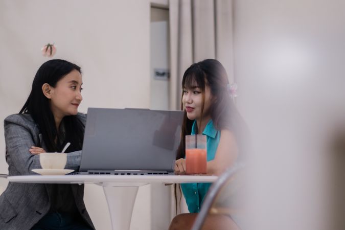 Engaging Discussion, Two colleagues work on a laptop in a modern