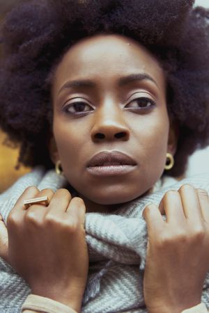 Portrait of woman with afro hair wearing gray scarf