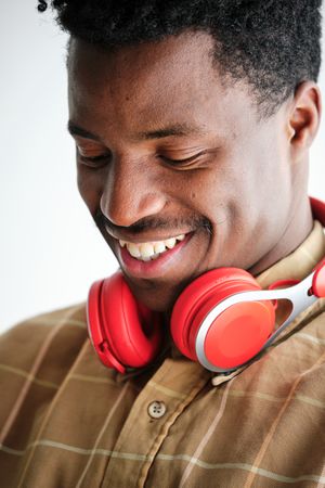 Cheerful Black man with headphones on white background