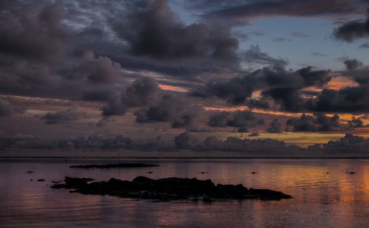 Rocks in the Indian Ocean under a colorful sunrise