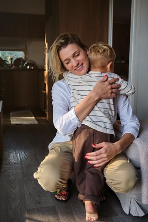Mother embracing son in cozy room