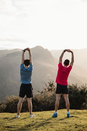 Sportsmen stretching after running in mountains