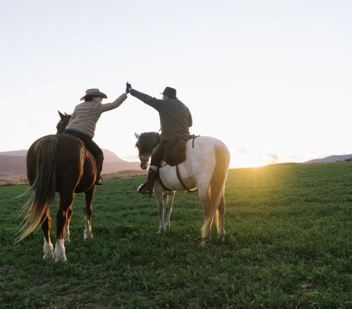 People on horses giving high five