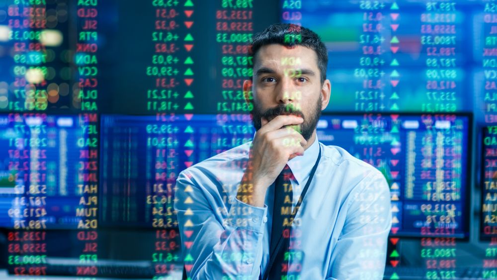 Stock Market Top Trader Looks at Projected Ticker Numbers and Graphs Running,