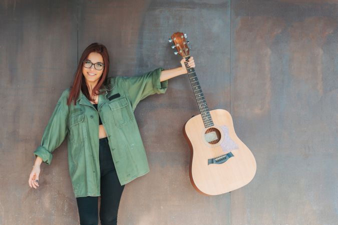 Woman in glasses leaning on wall
