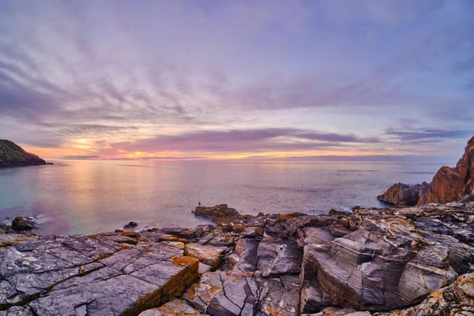 Gray rocky shore near ocean during golden hour