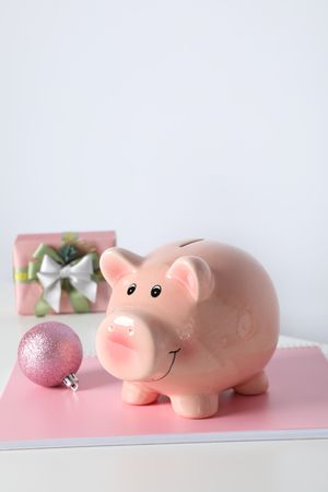 Piggy bank, gift box and notepad on neutral background, close up