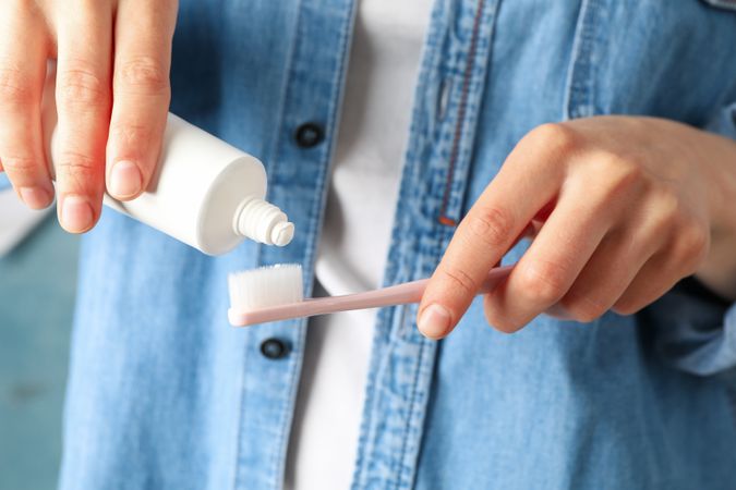 Woman squeezes toothpaste, close up. Dental care